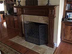 Custom tile around this fireplace provides tastefully subtle accenting against the backdrop of rich woodwork