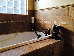 The custom tile surrounding this luxurious tub is not just functional, it enhances the serenity of the environment